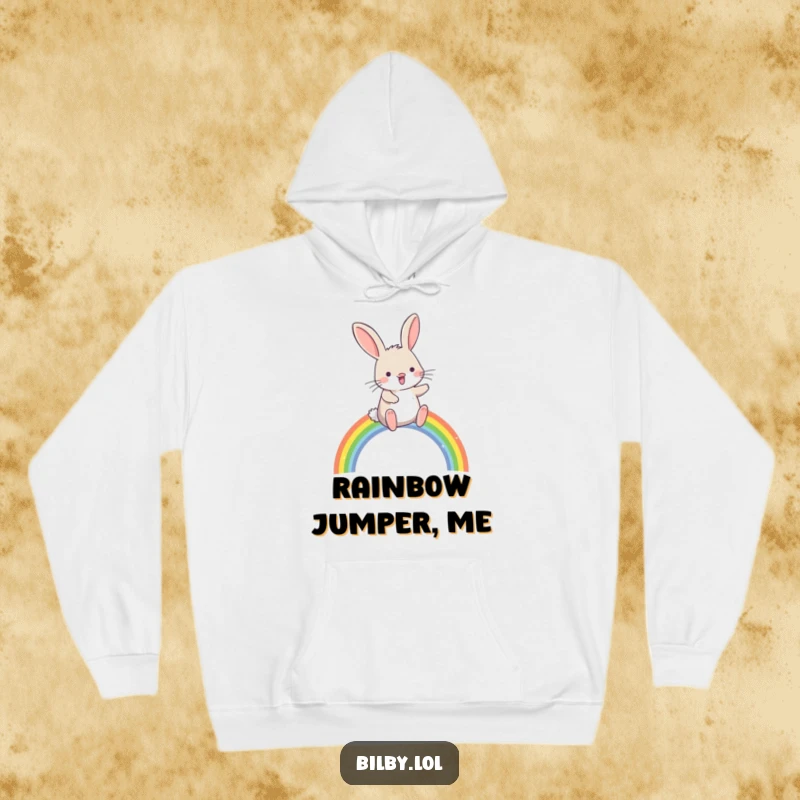Funny bilby hopping joyfully over a small, sparkling rainbow arc on a cozy hoodie, great for a humorous and magical gift.